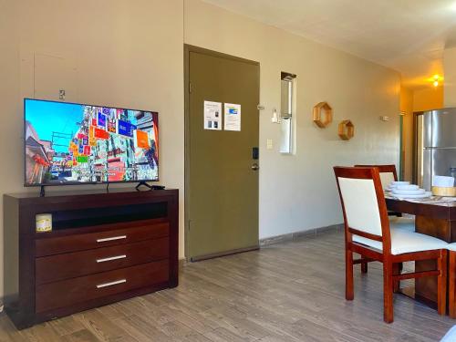 a living room with a flat screen tv and a table at Departamentos Raices - Jardines del Lago in Mexicali