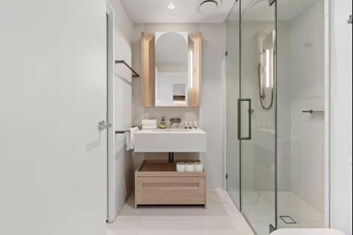 a bathroom with a sink and a glass shower at CASSA QW - Queens Wharf Modern Apartments Managed by The Cassa in Brisbane