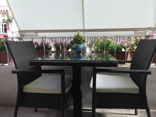 a glass table with two chairs and a vase on it at B&B Pellicano Guest House in Reggio Calabria