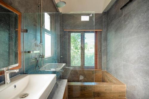 een badkamer met een bad en een wastafel bij Plenary Khao Kho in Ban Nong Chaeng