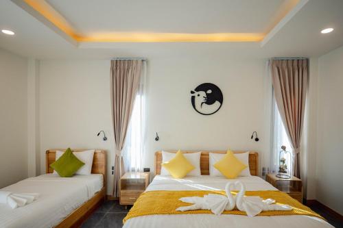 een slaapkamer met twee bedden met witte lakens bij Plenary Khao Kho in Ban Nong Chaeng