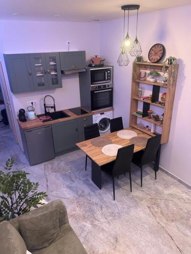 a kitchen with a wooden table and a dining room at L&A Appartement in Montargis