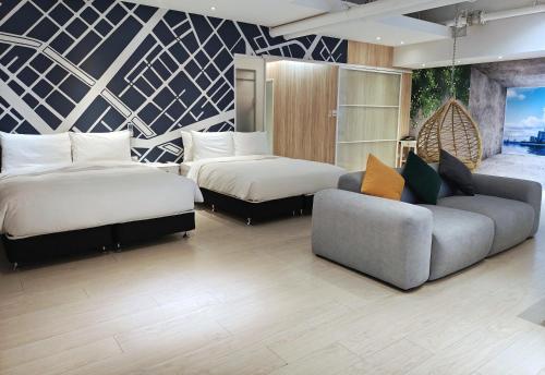 a hotel room with two beds and a couch at Hotel Mapp in Taichung