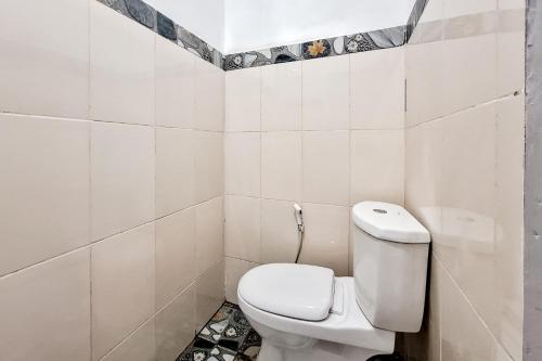 a white bathroom with a toilet in a room at RedDoorz at Hotel Lavender Kertajati in Gadel