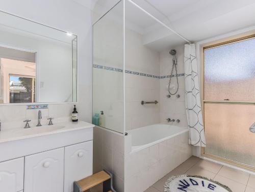 ein weißes Badezimmer mit Badewanne und Waschbecken in der Unterkunft Cabarita Barefoot Beach House in Cabarita Beach