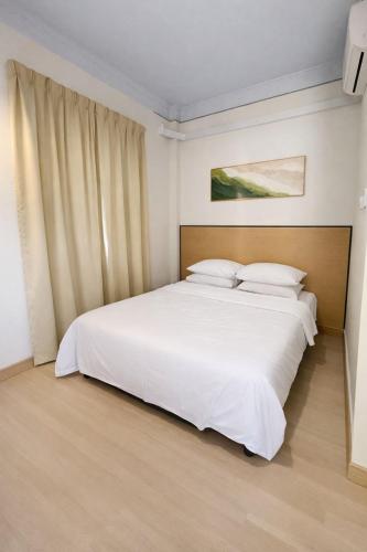 a bedroom with a large bed with white sheets at Kanza Beach Inn in Marang