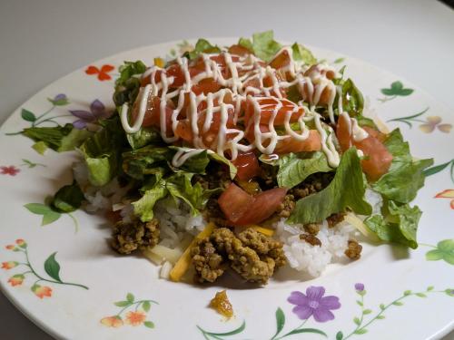 ein Teller mit Essen mit Salat und Reis in der Unterkunft Big Tree JUDO ハウス in Urazoe