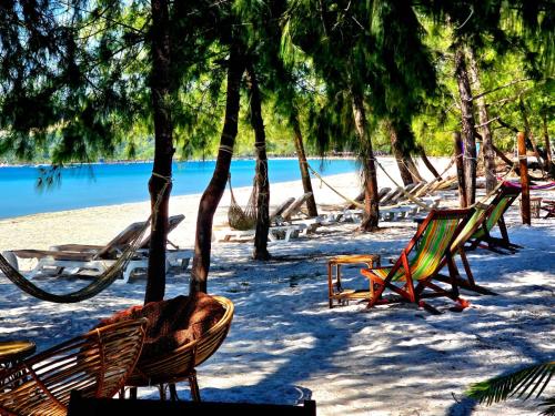 a group of chairs and hammocks on a beach at White Beach Hostel in Koh Rong Island