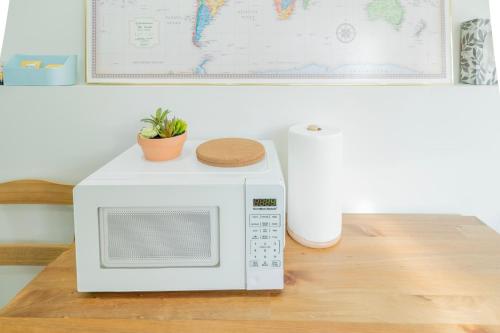 a white microwave oven sitting on a wooden table at Quiet, cozy 2BR1BA private entry suite near Skytrain in Vancouver