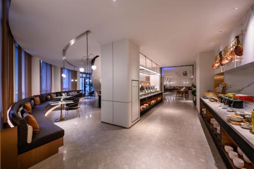 ein Restaurant mit einer Bar mit Stühlen und Tischen in der Unterkunft Mercure Shanghai Jinqiao in Shanghai