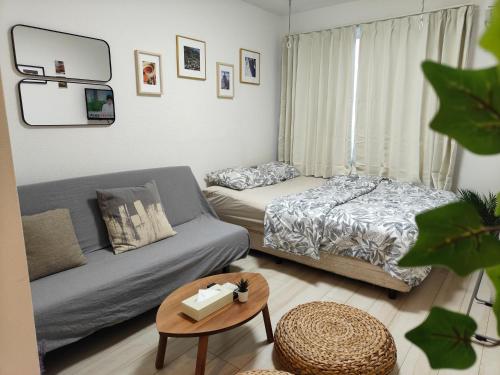 a living room with a bed and a couch at ティエラ北池袋 in Tokyo