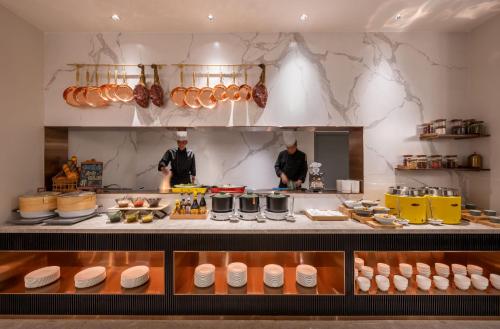 eine Küche mit zwei Köchen in der Küche in der Unterkunft Mercure Shanghai Jinqiao in Shanghai