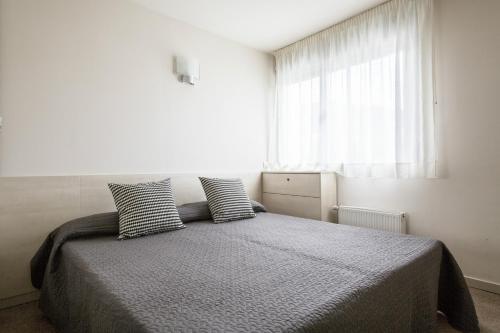 um quarto com uma cama com duas almofadas em Residencia Universitaria Manuel Agud Querol em San Sebastián