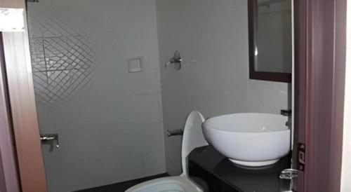 a bathroom with a white toilet and a sink at The Grande Suites in Surigao