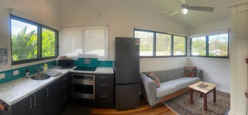 a kitchen with a couch and a sink in a room at Coffs Harbour Sanctuary in Coffs Harbour