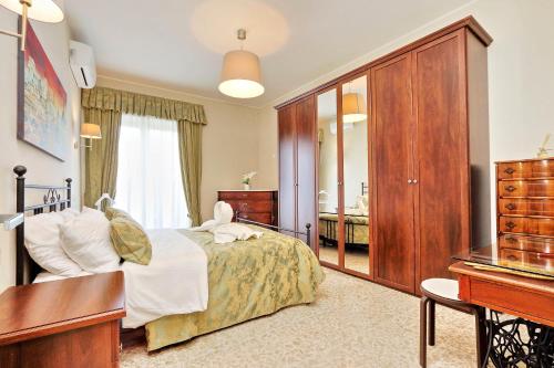 a bedroom with a bed and a dresser and a desk at Oksana's Bernadette Apartment in Rome