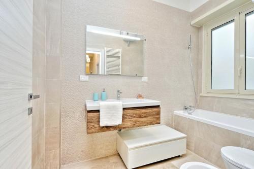 a bathroom with a sink and a toilet and a mirror at Oksana's Bernadette Apartment in Rome