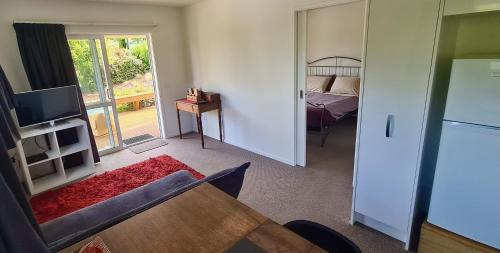 a living room with a bed and a tv and a kitchen at Best of Both Worlds Between City & Sea Holiday House in Nelson
