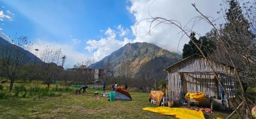a small shack in a field with a mountain at Hippy Hyde Kalga in Kalgha