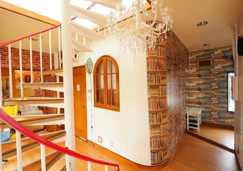 a living room with a staircase and bookshelves at Koiwa Guesthouse Tokyo in Tokyo