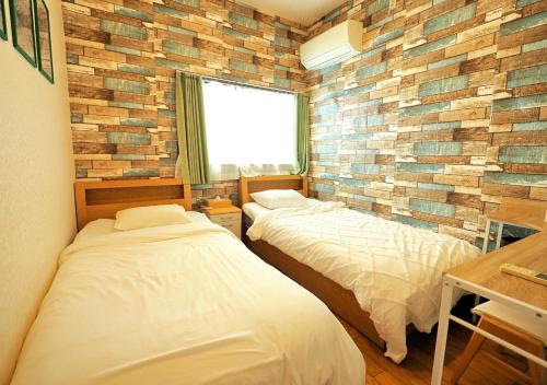 En eller flere senge i et værelse på Koiwa Guesthouse Tokyo