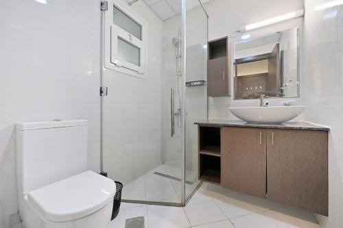 a bathroom with a toilet and a sink and a shower at One Bedroom Apartment in the Heart of Dubai Silicon Oasis in Dubai