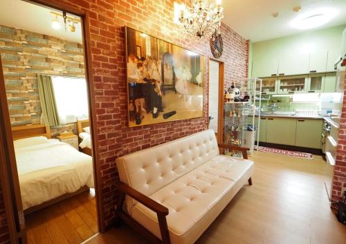 a living room with a couch and a brick wall at Koiwa Guesthouse Tokyo in Tokyo