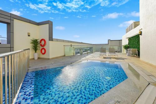 a swimming pool in front of a house at One Bedroom Apartment in the Heart of Dubai Silicon Oasis in Dubai