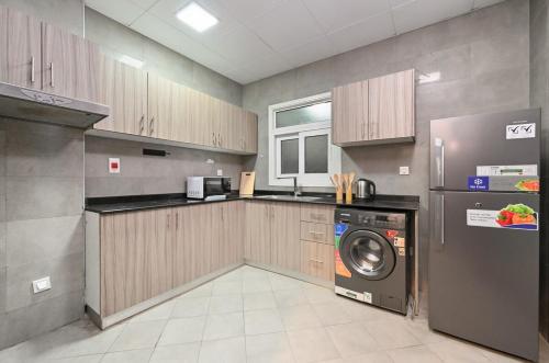 a kitchen with a washer and a washing machine at One Bedroom Apartment in the Heart of Dubai Silicon Oasis in Dubai
