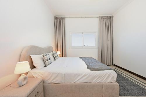 a bedroom with a large bed and a window at One Bedroom Apartment in the Heart of Dubai Silicon Oasis in Dubai