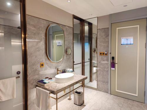 een badkamer met een wastafel en een spiegel bij Mercure Anyang Downtown in Anyang