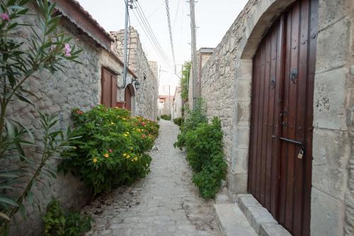 an alley with a door and some plants and flowers at Oinoessa Traditional Boutique Guest Houses in Lofou