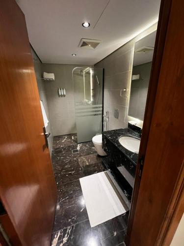 a bathroom with a sink and a toilet and a mirror at فندق شادن الفخامة in Taif