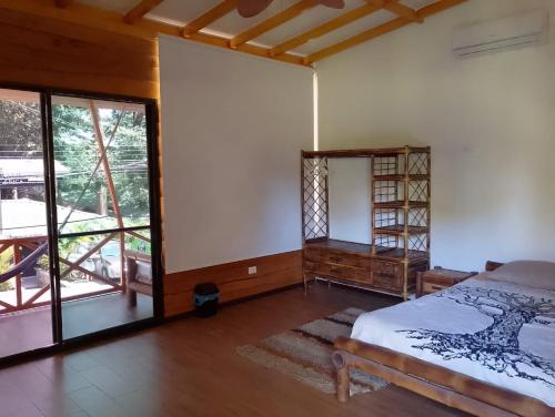 a bedroom with a bed and a large window at Domi Hostel in Dominical