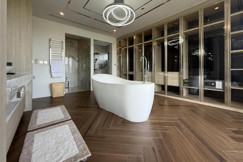 a bathroom with a white tub and wooden floors at Villa Lion Phuket in Phuket