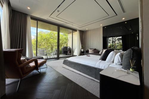 a bedroom with a large bed and a large window at Villa Lion Phuket in Phuket