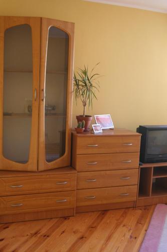 a wooden dresser with a dresser with a tv at Apartament Rodzinny w Kaliszu in Kalisz