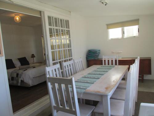 a dining room with a table and a bedroom at Point Village Accommodation - Point Road 20 in Mossel Bay