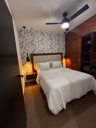 a bedroom with a white bed with a ceiling fan at Arexperience in Puerto Vallarta