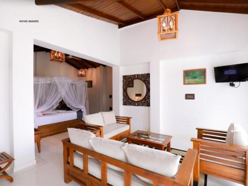 a living room with a couch and a bed at Florain Otium Talpe - 3 Bedroom Oceanfront Villa in Unawatuna