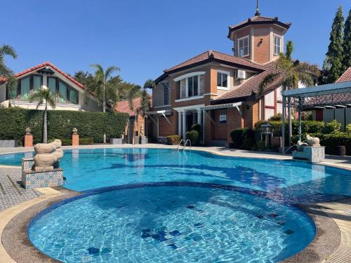 a large swimming pool in front of a house at Rosie Garden & Home in Ban Bung