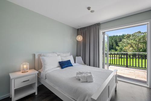 Un dormitorio blanco con una cama y un balcón. en HUs - Boutique Venue & Accommodation, en Riverhead