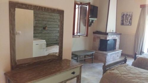 um espelho numa cómoda num quarto com lareira em Mathes em Klávsion