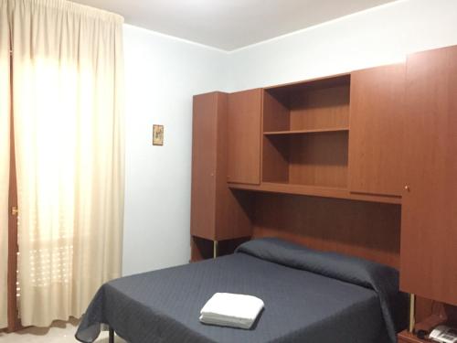 a bedroom with a bed and a book shelf at Castelvetere Hotel in Caulonia