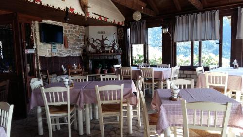uma sala de jantar com mesas e cadeiras e uma lareira em Mathes em Klávsion