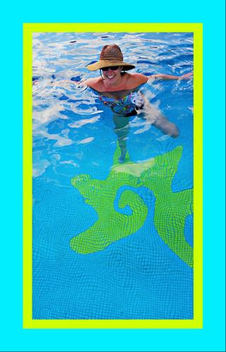 a person in a swimming pool with a hat in the water at Villa Star of the Sea in Barra de Navidad