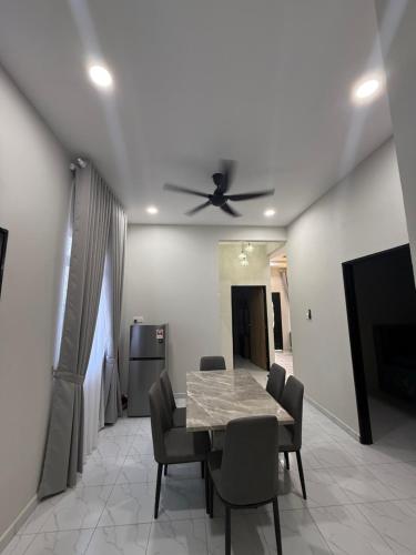 een eetkamer met een tafel en een plafondventilator bij Eyqa Homestay Pasir Mas in Pasir Mas