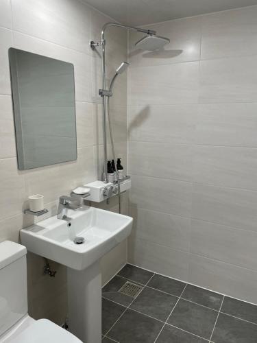 a white bathroom with a sink and a shower at Haemil Stay in Daegu