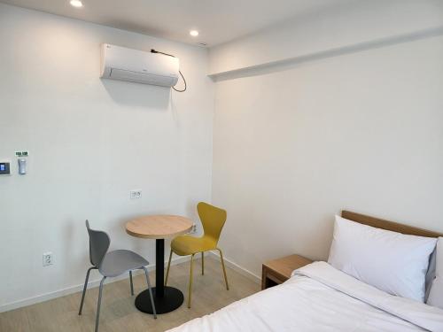 een slaapkamer met een bed, een tafel en stoelen bij Haemil Stay in Daegu