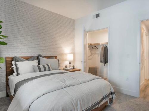 een slaapkamer met een groot bed en een bakstenen muur bij Magic Key Two-Bedroom Escape Near Disneyland With Free Parking in Anaheim